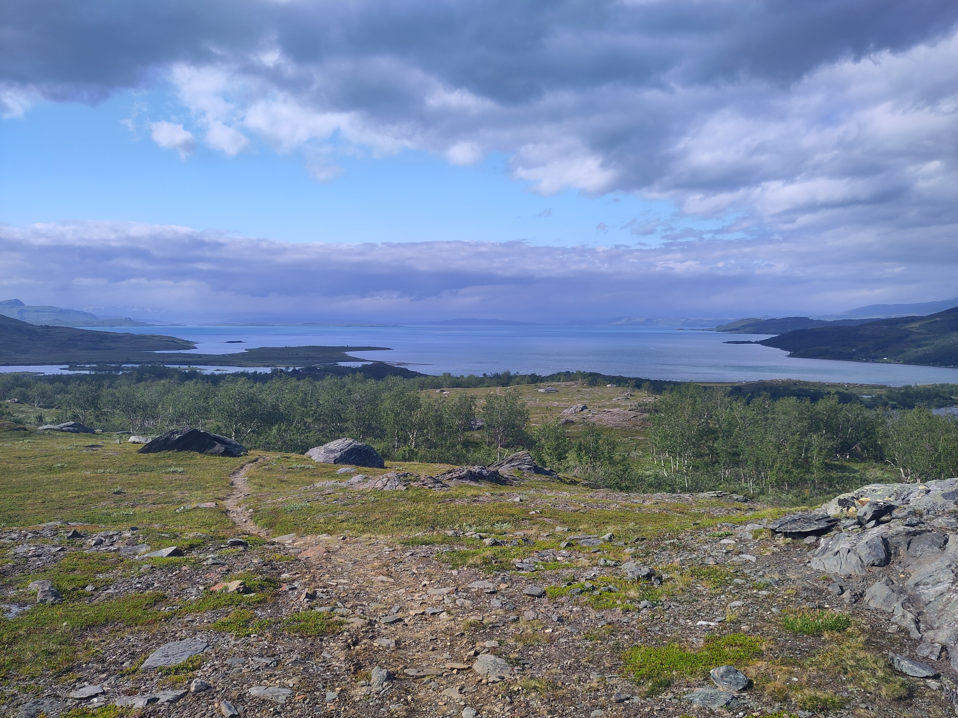 A big lake disappearing into the distance, low clouds hiding the far shore.