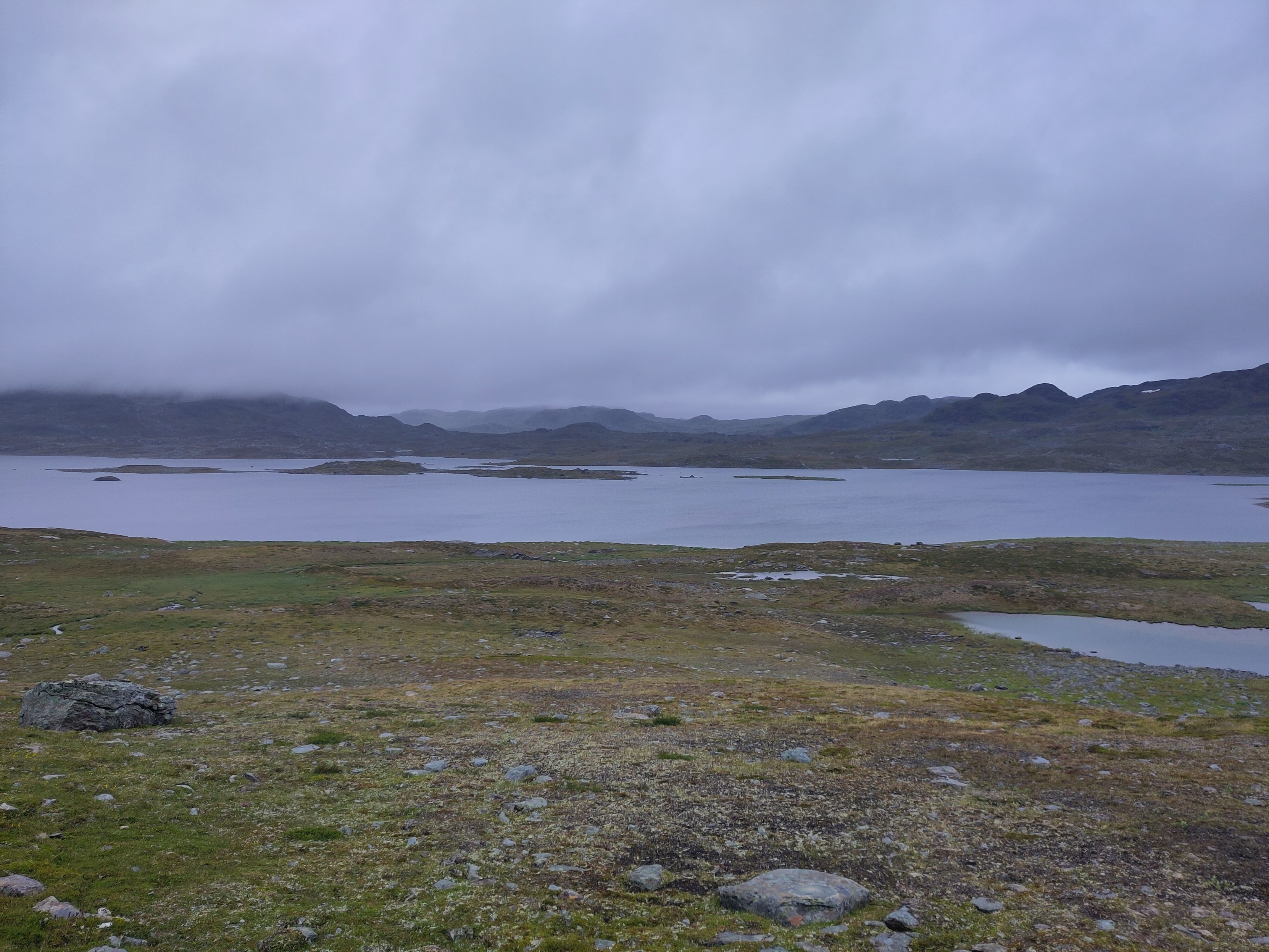 A distant lake with a string of islands in a mountain landscape.